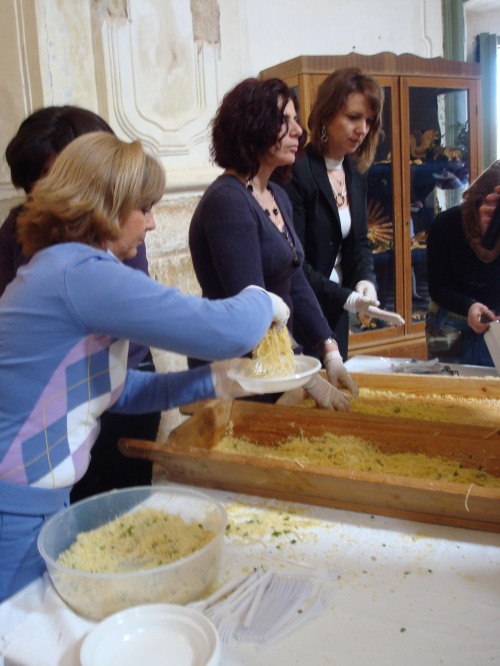 Local women serving up spaghetti with olive oil, cinnamon, sugar, parsley, and breadcrumbs.  This was given to the "Holy Family", as well as everyone in attendance.